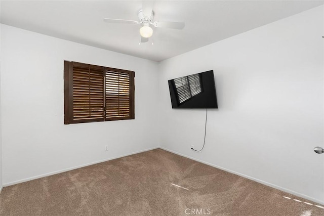 empty room featuring ceiling fan, carpet floors, and baseboards