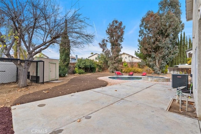 view of patio / terrace featuring a pool with hot tub, a storage shed, and central AC unit