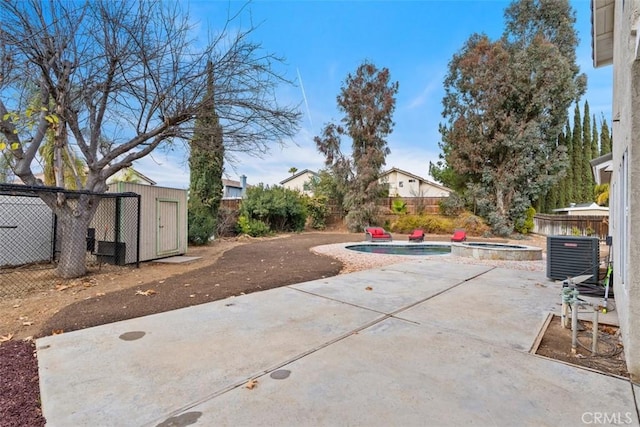 view of patio / terrace with a fenced backyard, a pool with connected hot tub, cooling unit, and an outbuilding