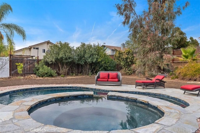 view of pool with a patio area, a fenced backyard, and a pool with connected hot tub