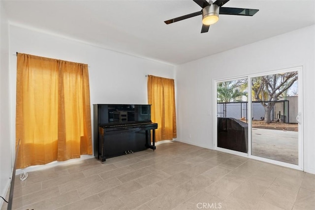 living room with ceiling fan and baseboards