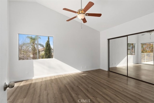 unfurnished bedroom featuring high vaulted ceiling, ceiling fan, baseboards, and wood finished floors