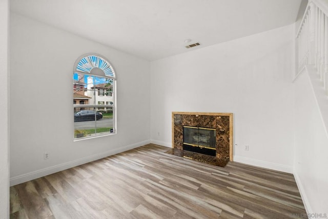 unfurnished living room with hardwood / wood-style flooring and a fireplace