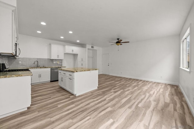 kitchen with sink, white cabinetry, stainless steel appliances, tasteful backsplash, and a kitchen island