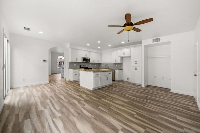 kitchen featuring white cabinetry, light hardwood / wood-style flooring, appliances with stainless steel finishes, and a kitchen island