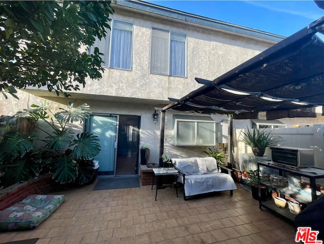 rear view of property featuring a pergola, an outdoor hangout area, and a patio