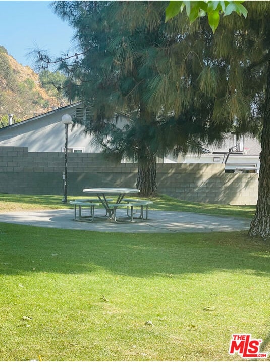 view of home's community with a yard and a patio