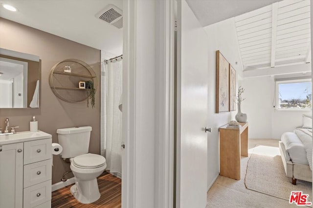 full bathroom with hardwood / wood-style floors, shower / tub combo with curtain, vaulted ceiling with beams, vanity, and toilet