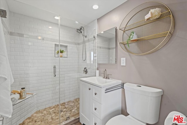 bathroom with vanity, toilet, and a shower with shower door