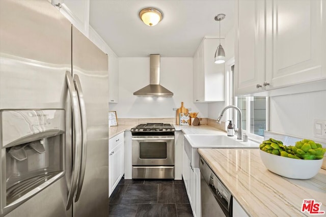 kitchen with pendant lighting, sink, white cabinetry, stainless steel appliances, and wall chimney exhaust hood