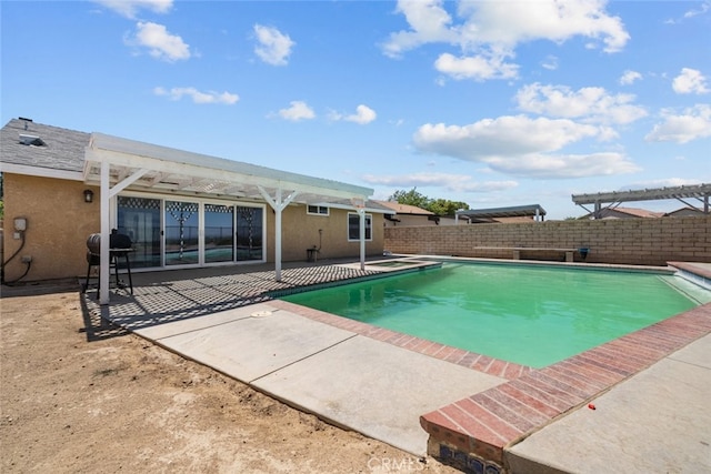 view of pool with area for grilling, a pergola, and a patio