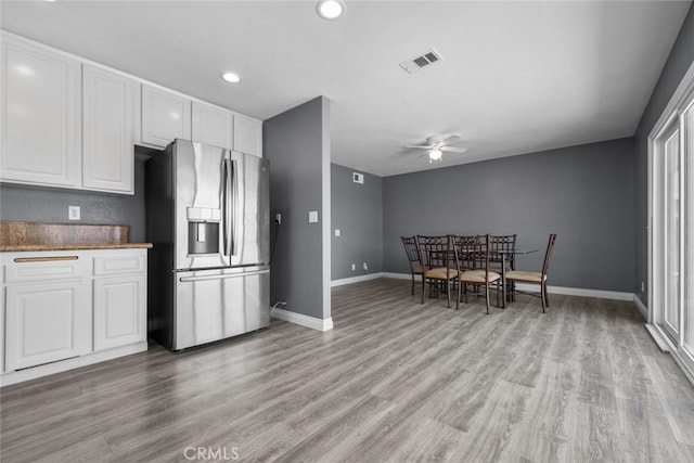 kitchen with white cabinetry, ceiling fan, light hardwood / wood-style floors, and stainless steel fridge with ice dispenser