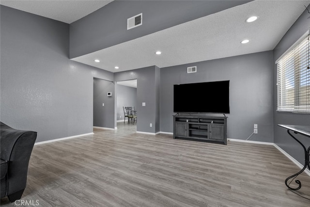 living room with light hardwood / wood-style floors and a textured ceiling