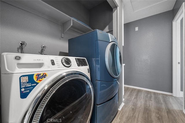 laundry area featuring wood-type flooring and independent washer and dryer