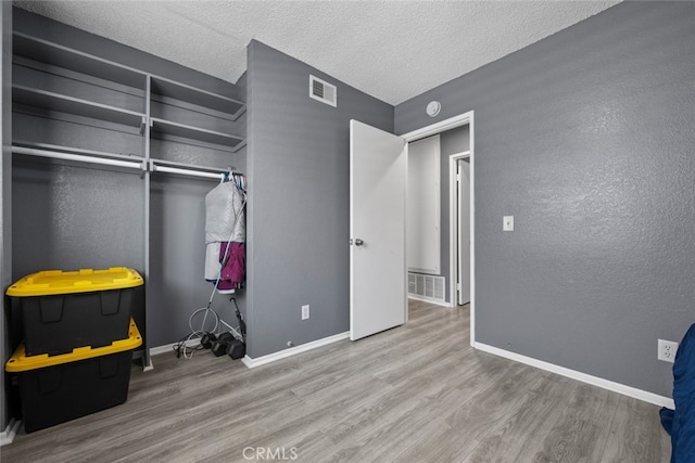 bedroom with wood-type flooring and a textured ceiling