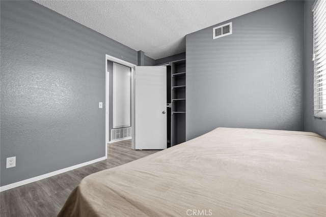 bedroom featuring dark hardwood / wood-style floors and a textured ceiling