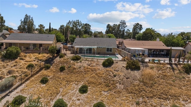 back of property with a fenced in pool and a patio