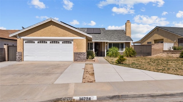 view of front of house featuring a garage and solar panels