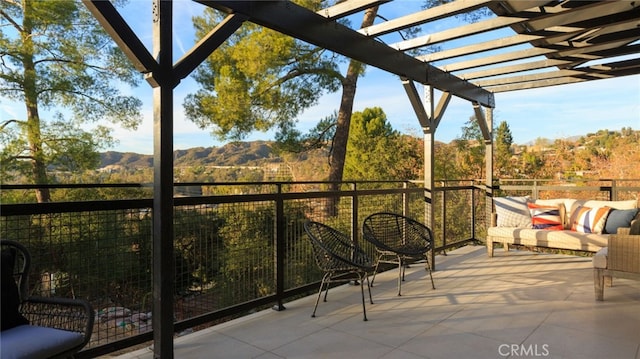 balcony featuring a mountain view, an outdoor hangout area, and a pergola