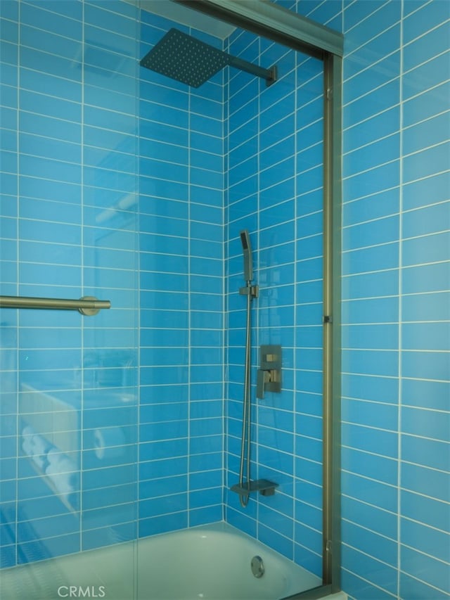 bathroom featuring combined bath / shower with glass door