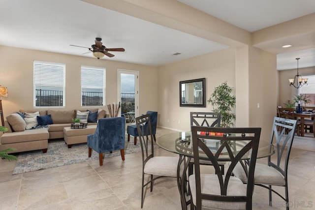 dining area featuring ceiling fan with notable chandelier and a healthy amount of sunlight