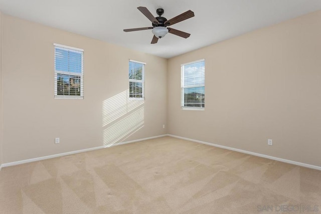 carpeted spare room with ceiling fan