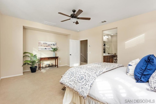 bedroom featuring ceiling fan, light colored carpet, and ensuite bathroom