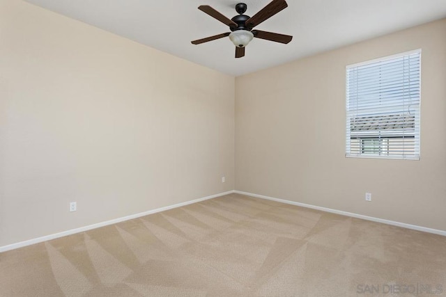 spare room with ceiling fan and light carpet