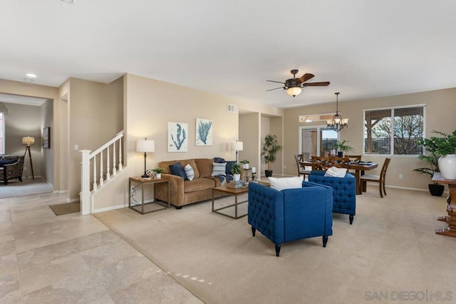 carpeted living room featuring ceiling fan with notable chandelier