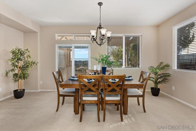 carpeted dining space featuring a chandelier