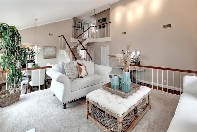 living room with crown molding, a towering ceiling, and a notable chandelier