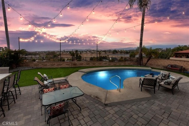 pool at dusk featuring a patio