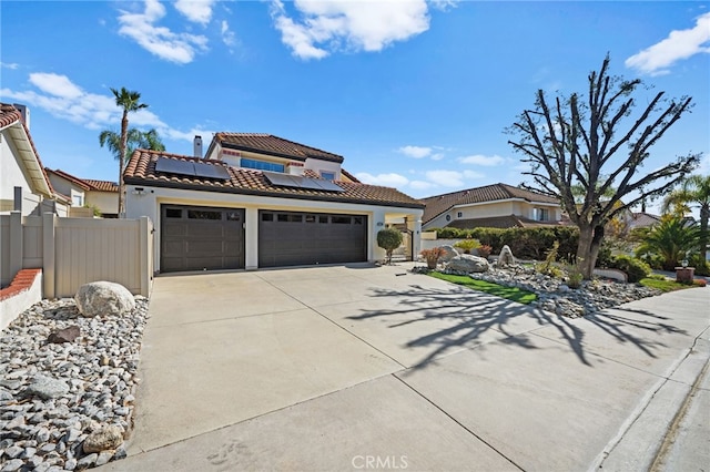 mediterranean / spanish-style house with a garage and solar panels