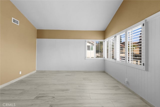 unfurnished room with vaulted ceiling and light hardwood / wood-style flooring