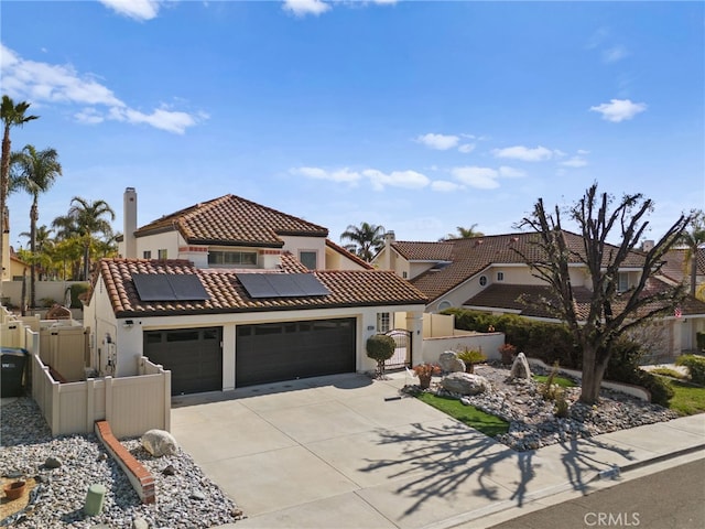 mediterranean / spanish-style home featuring a garage and solar panels