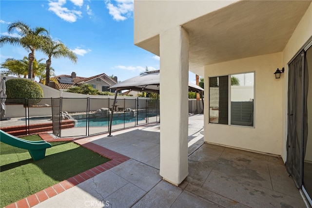 view of patio / terrace featuring a fenced in pool and a gazebo