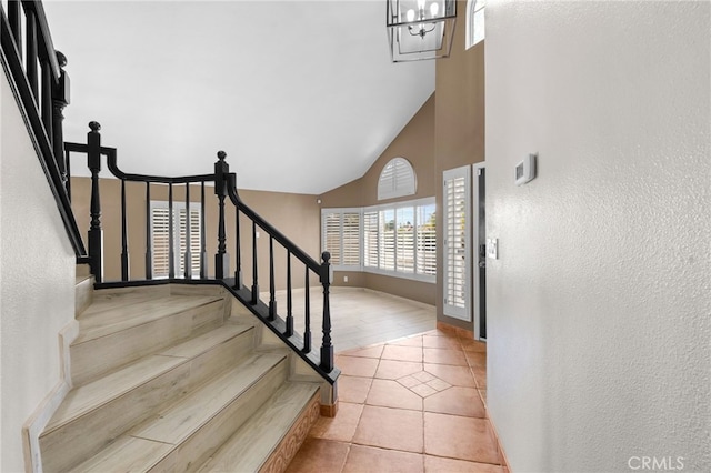 entrance foyer featuring light tile patterned floors and high vaulted ceiling