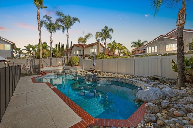 pool at dusk featuring a patio area