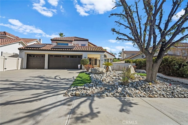 mediterranean / spanish house featuring a garage and solar panels