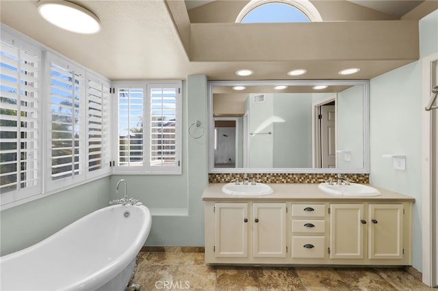 bathroom with vanity and a tub