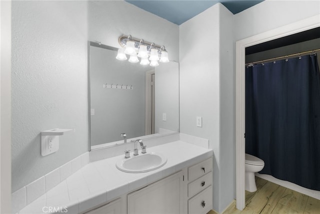 bathroom with vanity, wood-type flooring, and toilet