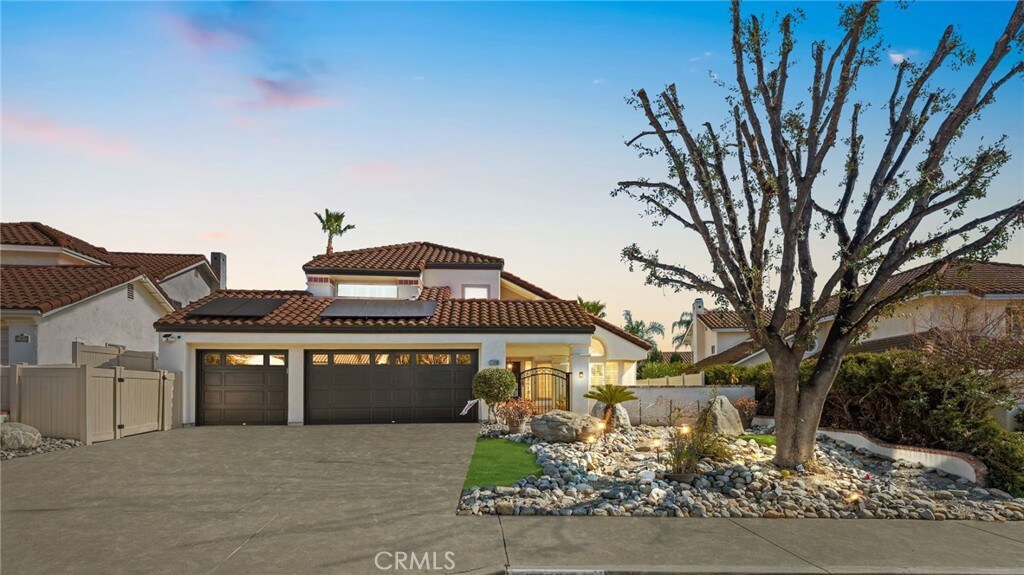 mediterranean / spanish-style home featuring a garage and solar panels