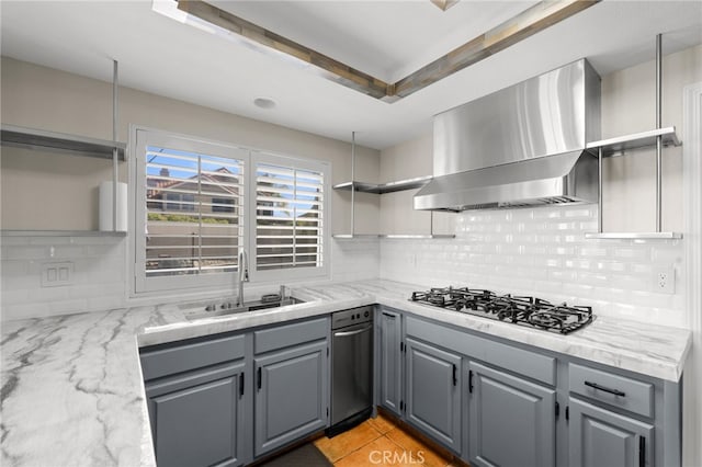 kitchen with sink, gas stovetop, light stone countertops, decorative backsplash, and wall chimney exhaust hood