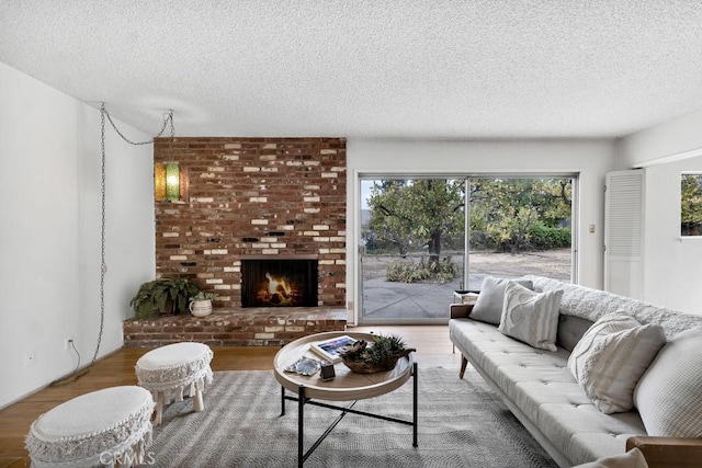 living room featuring hardwood / wood-style flooring, a fireplace, and a textured ceiling