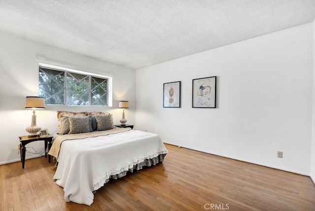 bedroom with hardwood / wood-style flooring and a textured ceiling