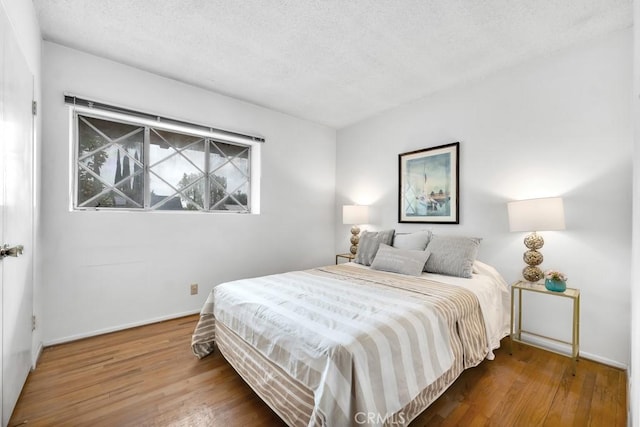 bedroom featuring hardwood / wood-style flooring and a textured ceiling