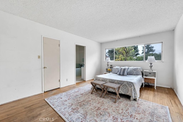 bedroom featuring a textured ceiling and light wood-type flooring