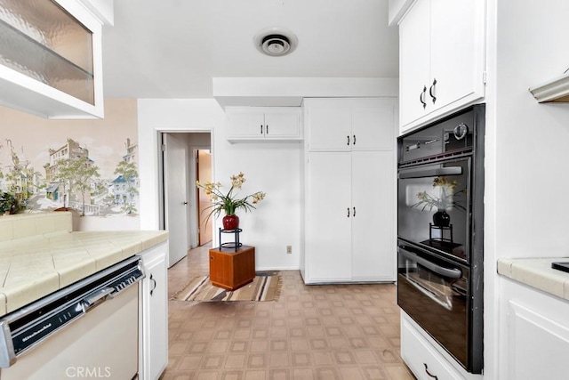 kitchen featuring white cabinetry, double oven, tile countertops, and dishwasher