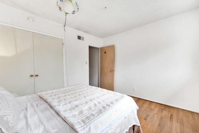 bedroom featuring wood-type flooring and a closet