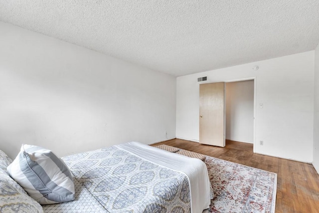 bedroom featuring wood-type flooring and a textured ceiling